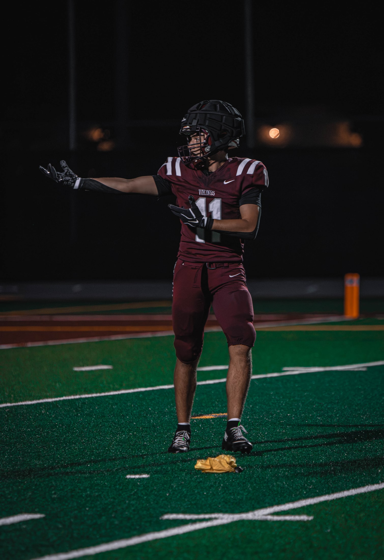 East Lyme number 11 signaling to teammates under the stadium lights