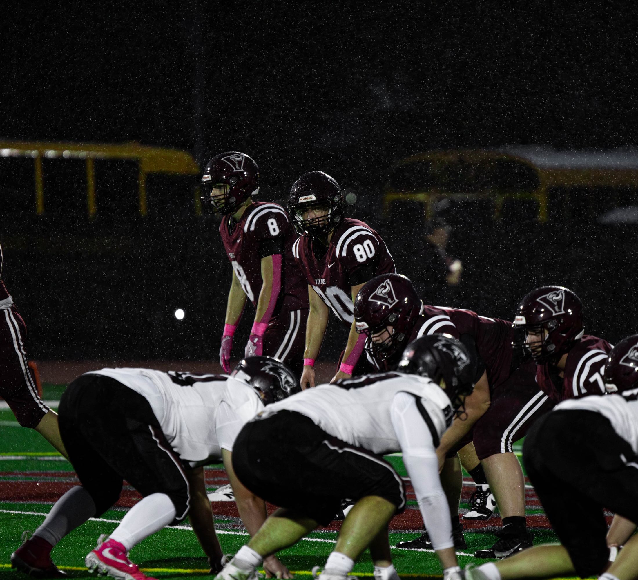 East Lyme football players lining up against the defense in the rain