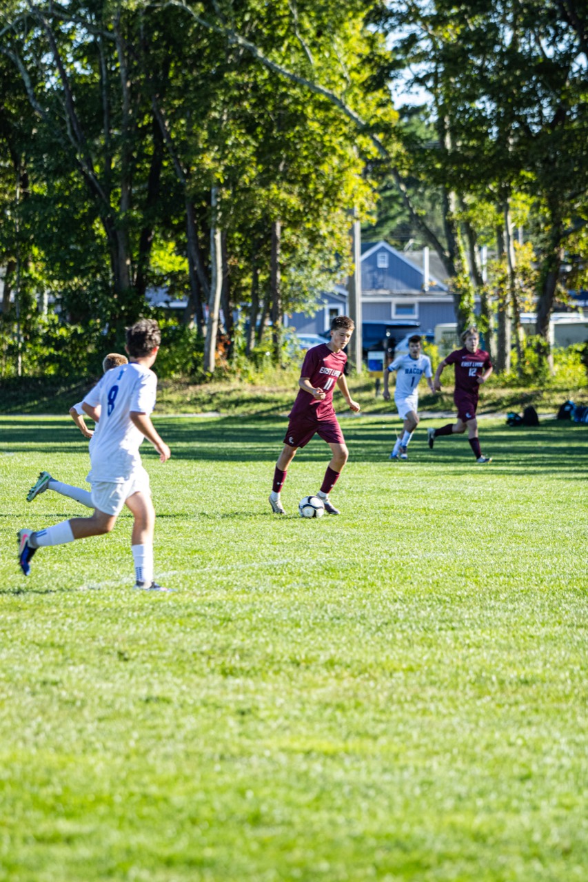 East Lyme number 11 moving the ball through midfield as defenders approach