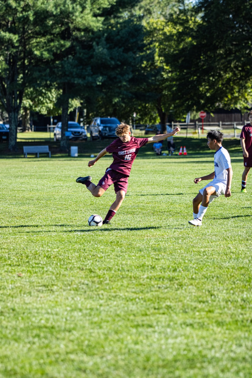 East Lyme soccer player striking the ball as a defender closes in